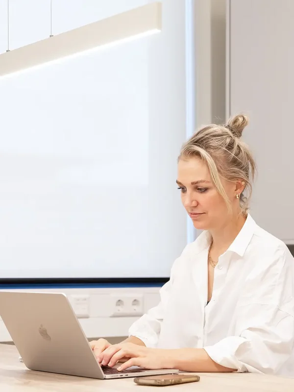 Drs. Halk dermatoloog met expertise in lipoedeem en liposuctie achter haar laptop bij Lipology Clinic